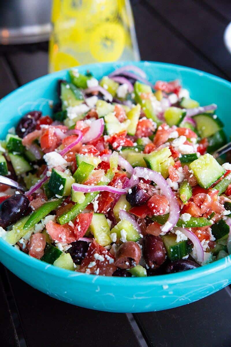 Greek Salad with Homemade Greek Salad Dressing in a jade blue bowl