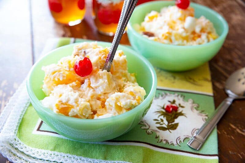 Ambrosia Salad ( 5 Cup Salad) in a green bowl with a spoon in it