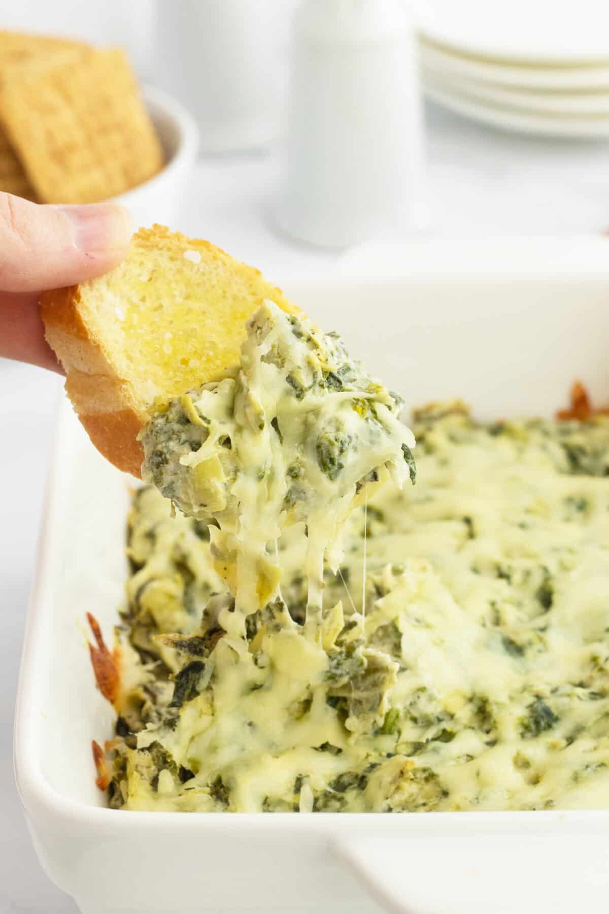 Hot and cheesy spinach and artichoke dip on bread