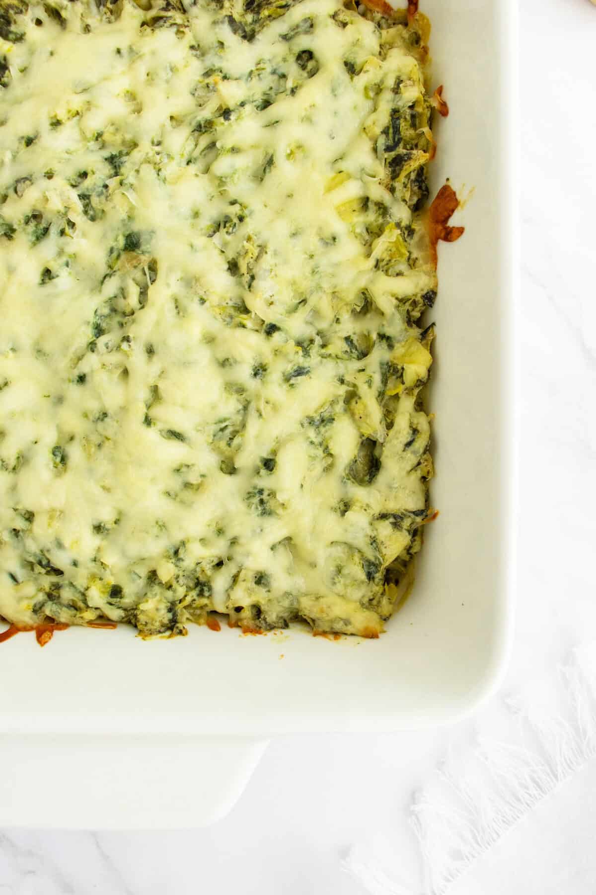 Hot and cheesy spinach and artichoke dip in baking pan