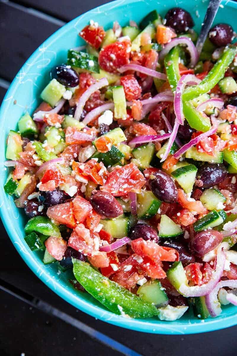 top down shot of Greek Salad with Homemade Greek Salad Dressing in a jade blue bowl