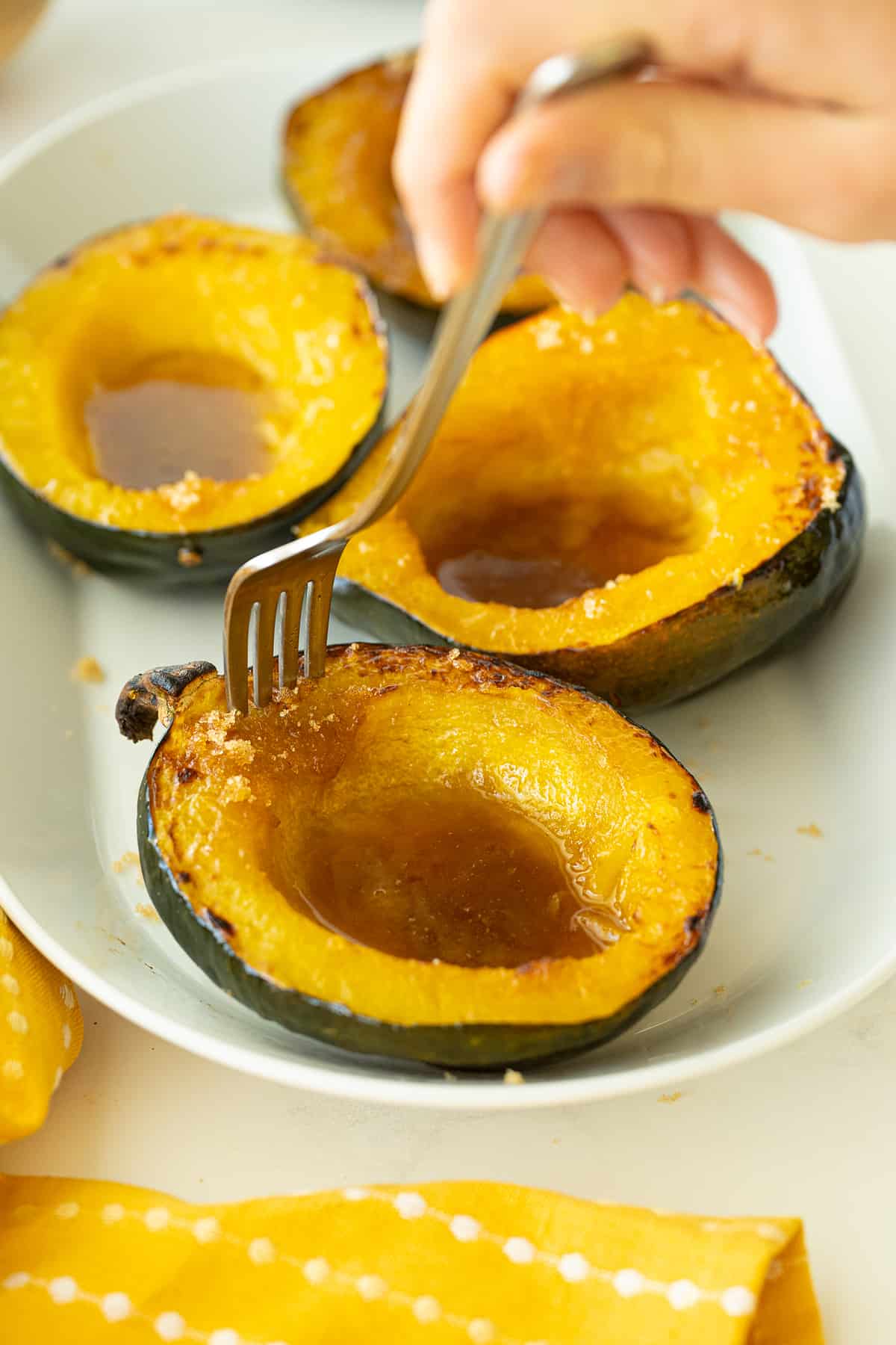 using a fork to have a part of baked cuts of Acorn Squash