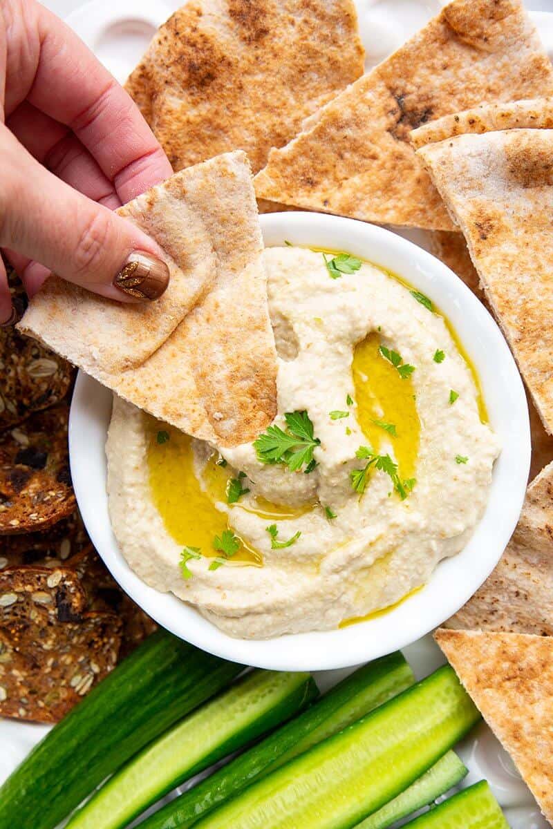 dipping an oven baked pita chip into Baba Ganoush