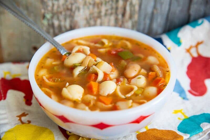 white soup bowl with Classic Homemade Minestrone Soup and a spoon on it