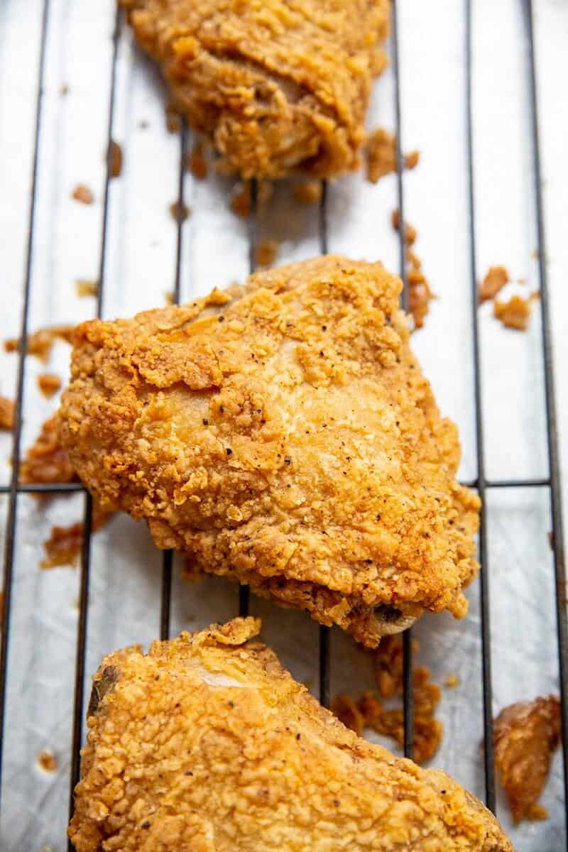 Crispy Fried Chicken in black wire baking rack with spaces in between them