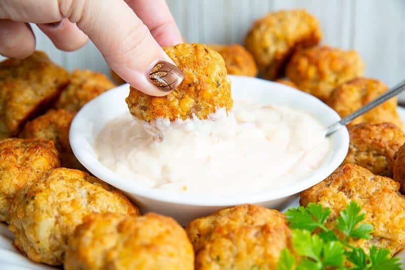 Sausage Balls with a dipping sauce at the center. Dipping a piece sausage ball in a sauce.