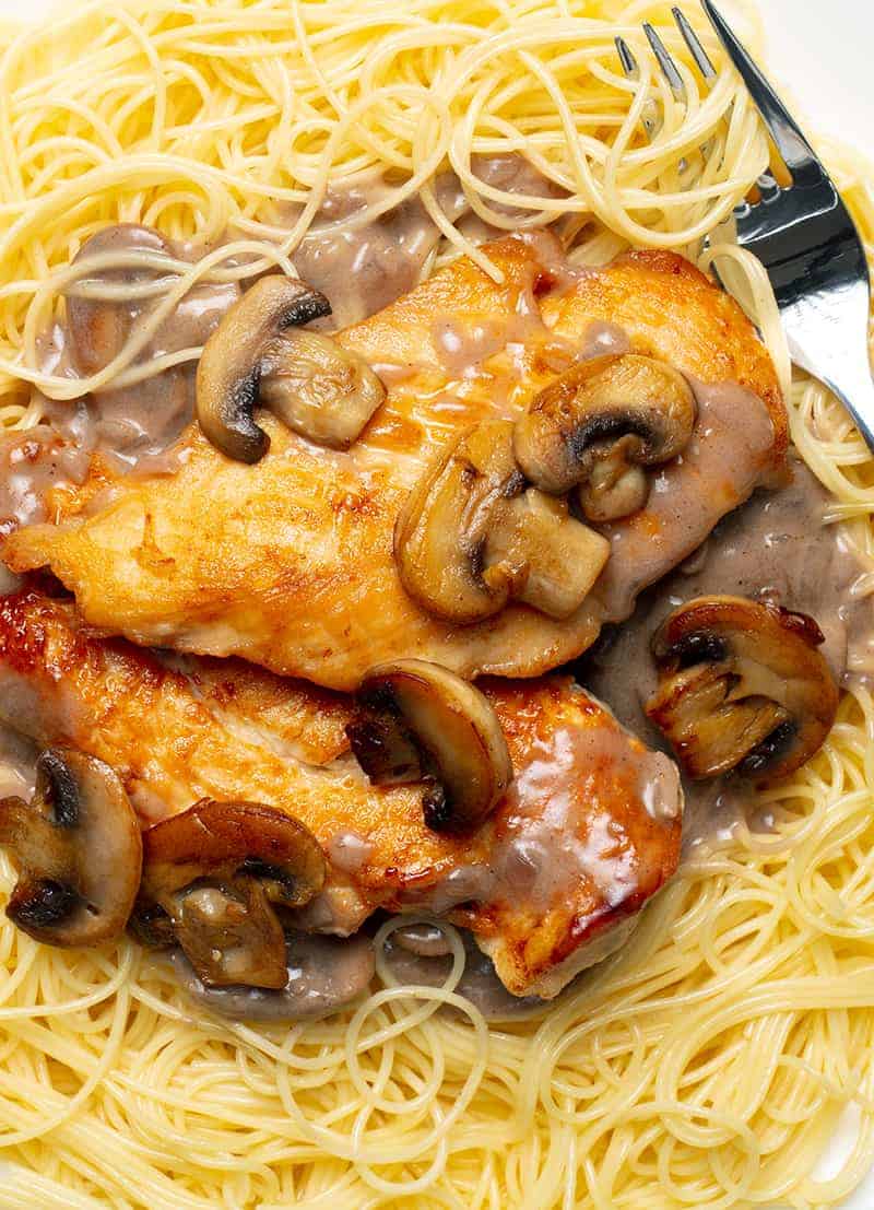 close up Chicken Marsala on angel hair pasta and a fork on it