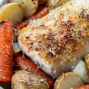 close up seasoned boneless Pork Loin Roast in a pan with potatoes and carrots