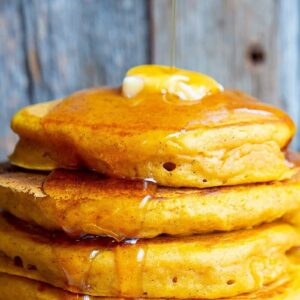 Close up of butter and syrup on a stack of pancakes