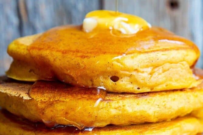 Close up of butter and syrup on a stack of pancakes