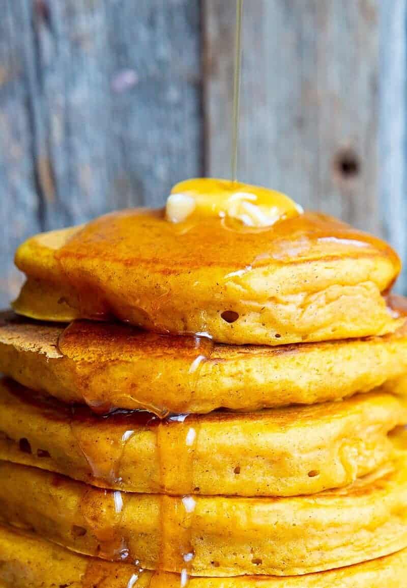Close up of butter and syrup on a stack of pancakes