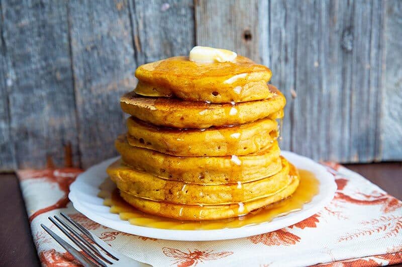 Stack of Pumpkin Pancakes on a plate with butter and syrup