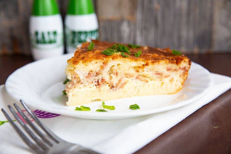 a slice of Bisquick Quiche in a white plate over a white cloth