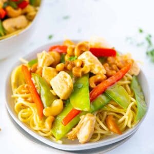 Cashew Chicken Stir Fry in a White Plate with Noodles