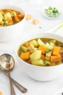 curried sweet potato and chicken soup with spoons beside bowl