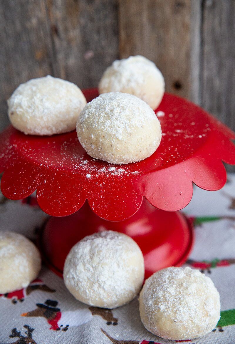 red cake holder with Pecan Sandies rolled in confectioner's sugar