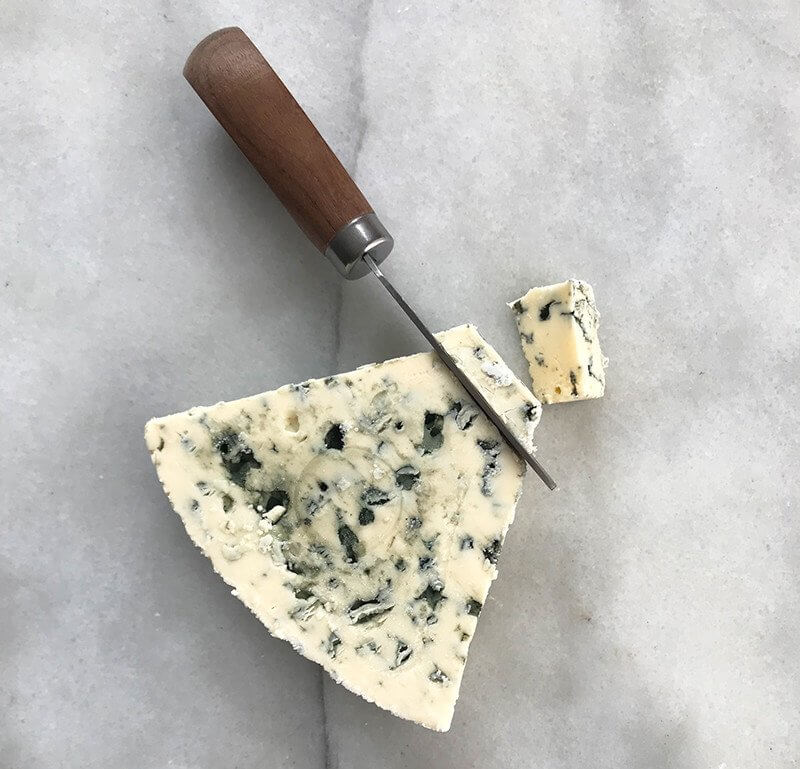 slicing Castello Extra Creamy Danish Blue Cheese