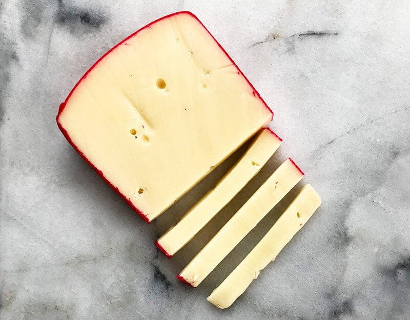 sliced Castello Fontina cheese on marble background