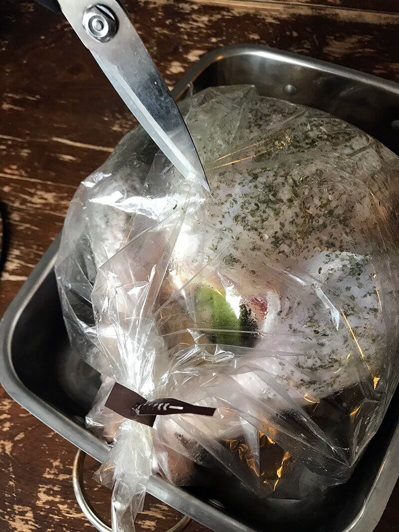 Cutting small holes into the top of the roasting bag to let steam out