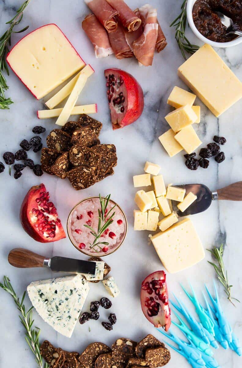 Perfect Cheeseboard with the other food items like Dried cherries, Rosemary Sprigs and Sliced Pomegranates