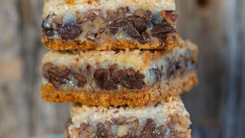 close up stack of Magic Cookie Bars in a dessert plate