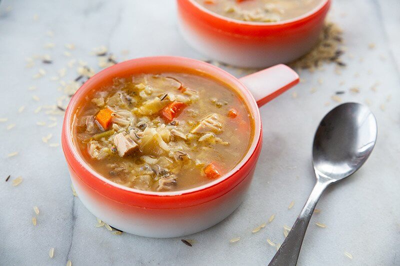 Turkey Carcass Soup and a spoon in a marble table