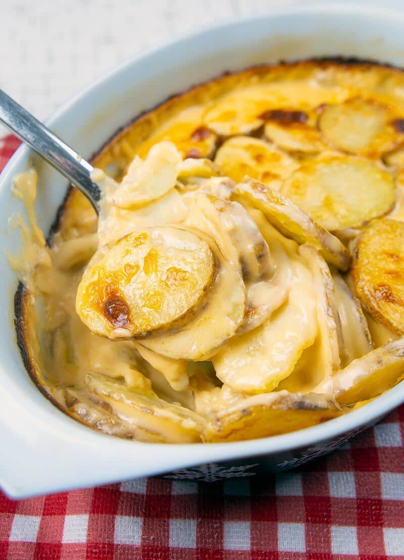 close up of Creamy Cheesy Scalloped Potatoes in a casserole dish