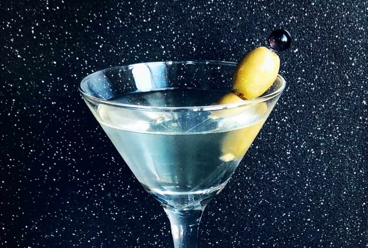 close up of Dirty Martini garnish with 2 olives on a pick