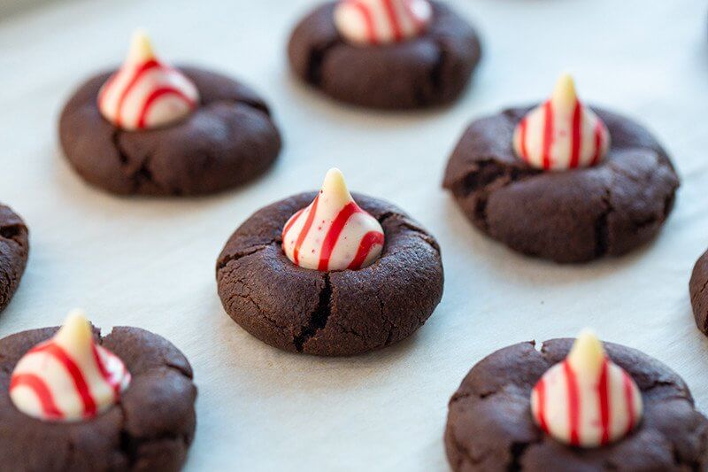 some pieces Chocolate Cookies with White Chocolate Peppermint Kisses on Top