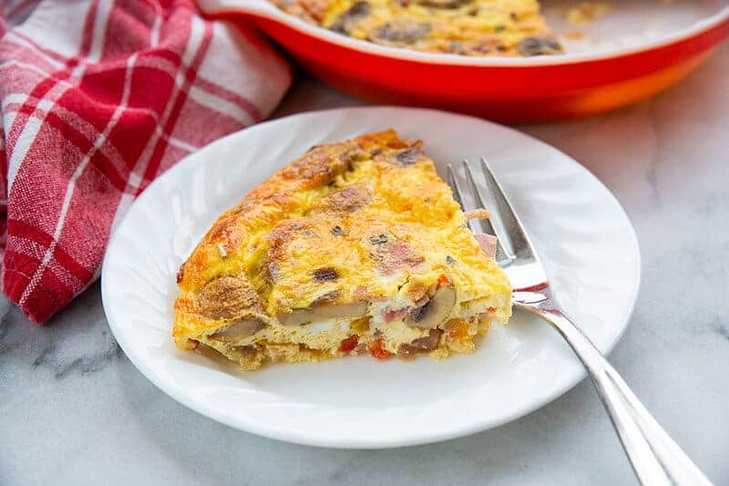 white plate with a slice of Ham & Mushroom Crustless Quiche and a fork