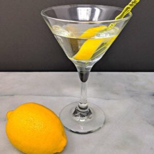 Top down shot of Vesper Martini and a fresh lemon on a marble table