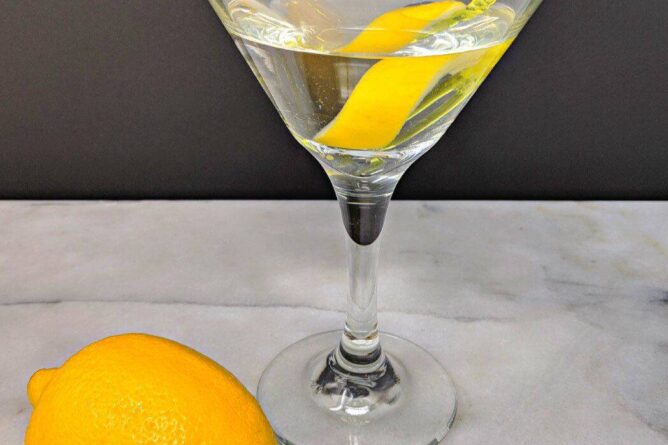 Top down shot of Vesper Martini and a fresh lemon on a marble table