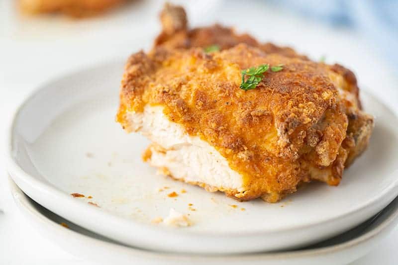 crispy-skinned air fryer chicken on a white plate