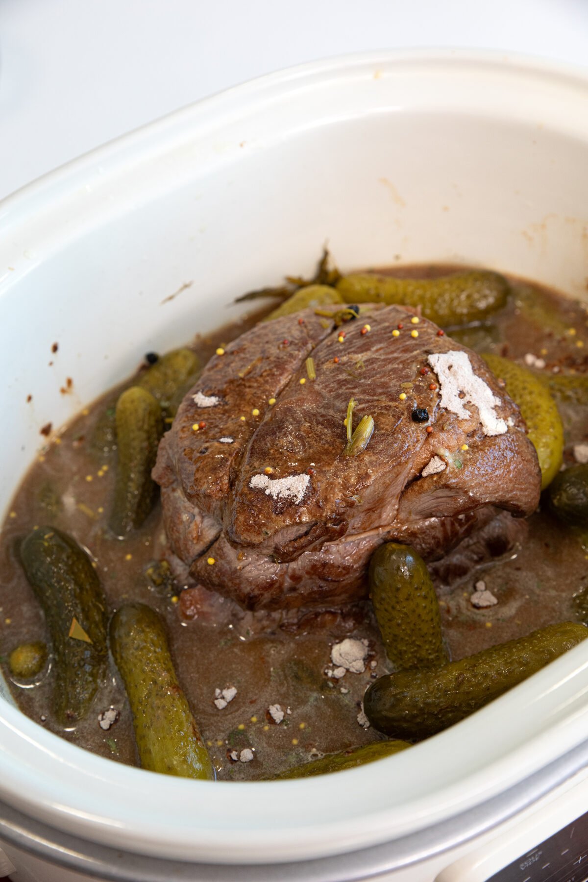 seared but uncooked dill pickle pot roast in slow cooker