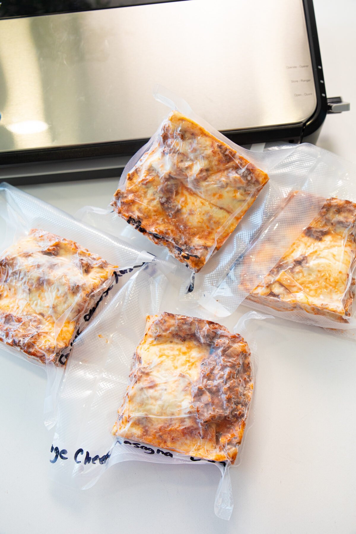 four pieces of frozen lasagna prepared for the freezer