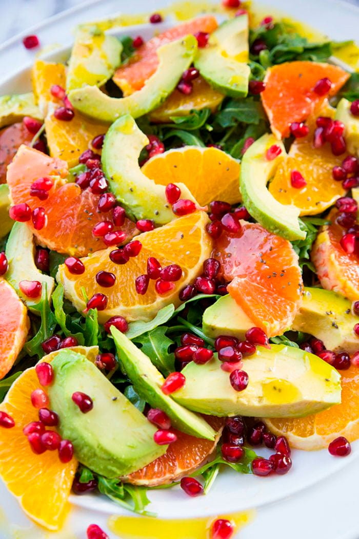 closeup of arugula,  slices of orange,avocado,grapefruit and pieces of pomegranate