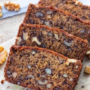 close up slices of Banana Nut Bread in a wood cutting board