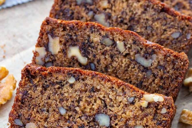 close up slices of Banana Nut Bread in a wood cutting board
