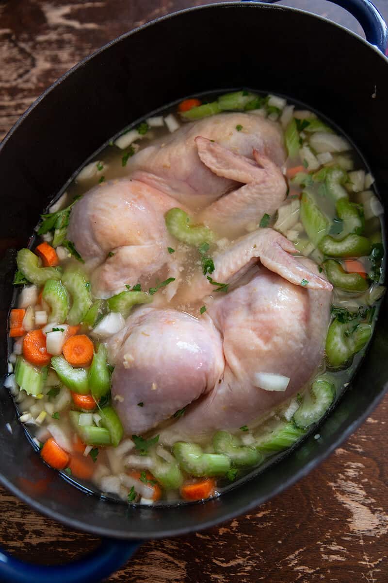 2 pieces of chicken with celery, carrot, onion, garlic, parsley and chicken stock in a large dutch oven