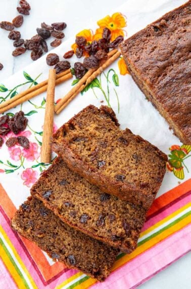 close up Raisins, cinnamon sticks and slices of Cinnamon Raisin Banana Bread