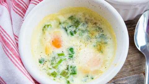 close up Shirred Eggs in a white soup bowl saucers