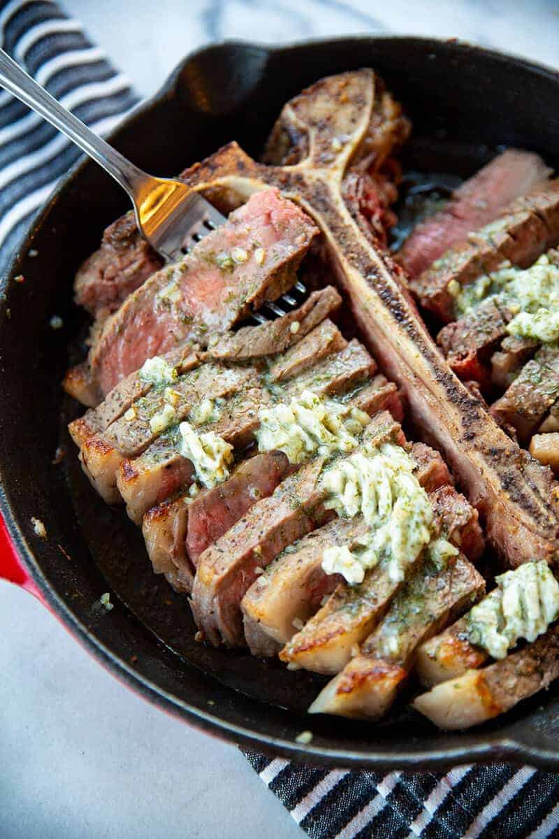 a slice of Skillet Porterhouse Steak with Garlic Dill Butter in a fork