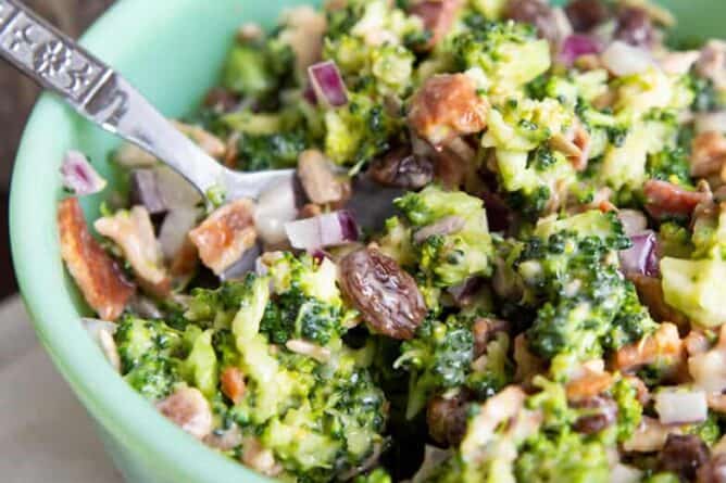 close up Bacon Broccoli Salad Recipe in a green Jadeite bowl with a spoon