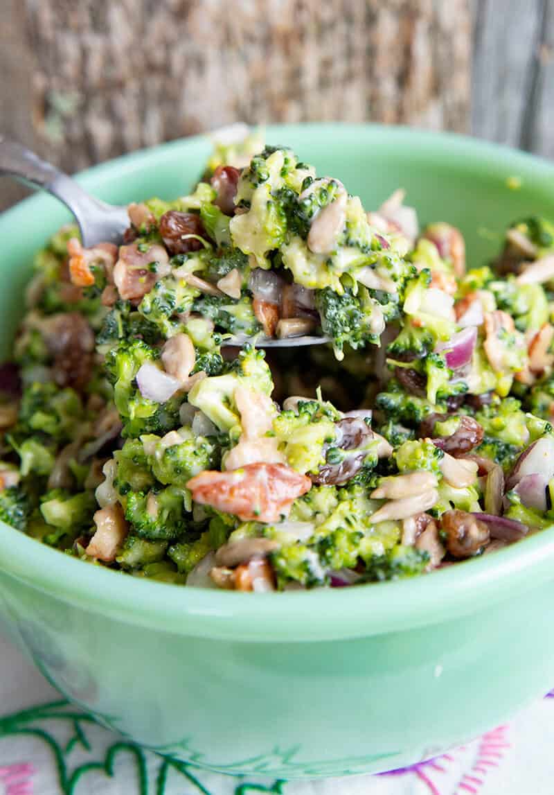 close up Bacon Broccoli Salad Recipe in a green Jadeite bowl with a spoon