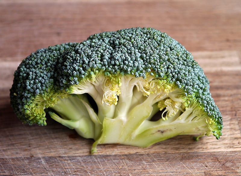 chopped broccoli on a wooden cutting board