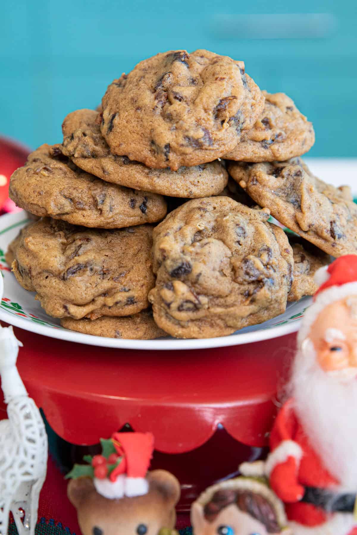 hermit cookies stacked on a plate, surrounded by vintage Christmas decor