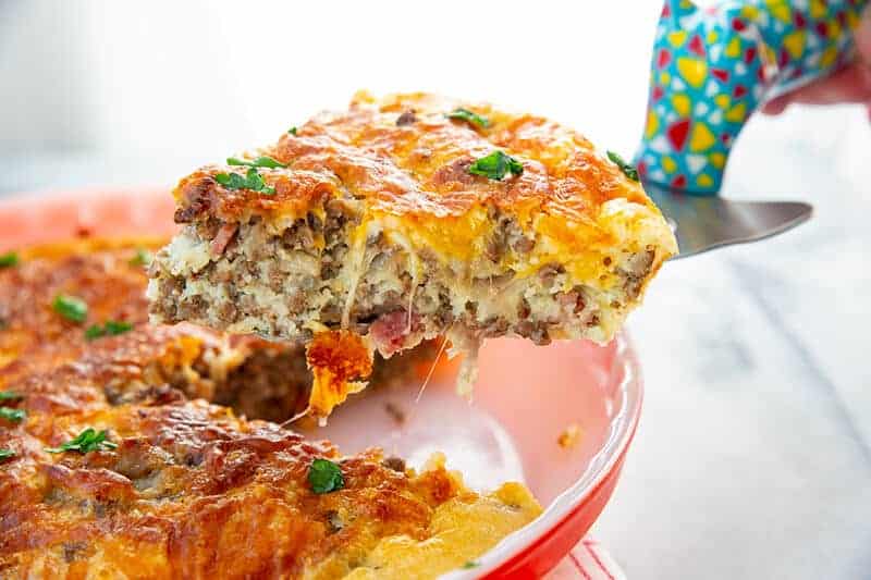 lifting a slice of Bisquick Impossible Cheeseburger Pie using a pie spatula