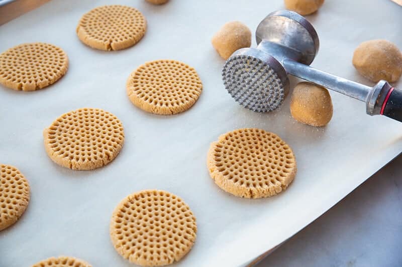 pressing down the cookie dough using a meat mallet