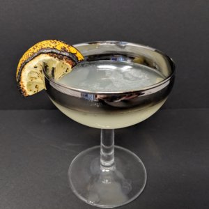 close up of a coupe with Corpse Reviver garnish with a little bit burned lemon slice