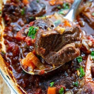 close up spoon of Osso Bucco from skillet